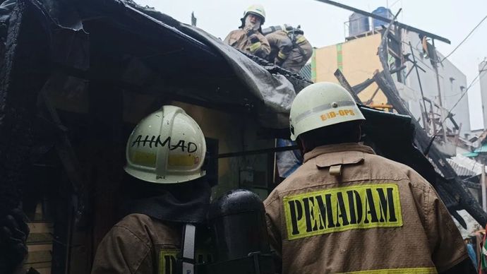 Petugas saat berupaya memadamkan api yang membakar kurang lebih 20 kamar indekos di Jakarta Pusat, Selasa (21/1/2025)