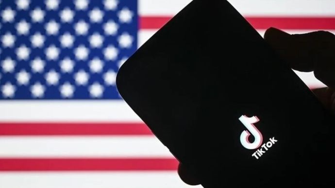 Ilustrasi - Logo TikTok pada ponsel dengan latar bendera Amerika Serikat.