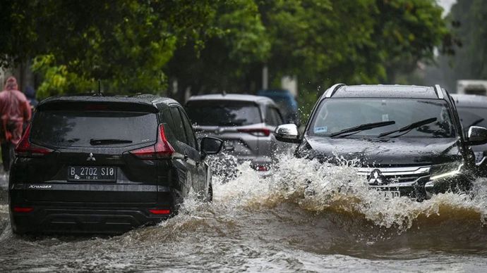 Arsip foto - Kendaraan melintasi banjir di Jalan Raya Gading Kirana, Kelapa Gading, Jakarta, Jumat, (22/3/2024). 