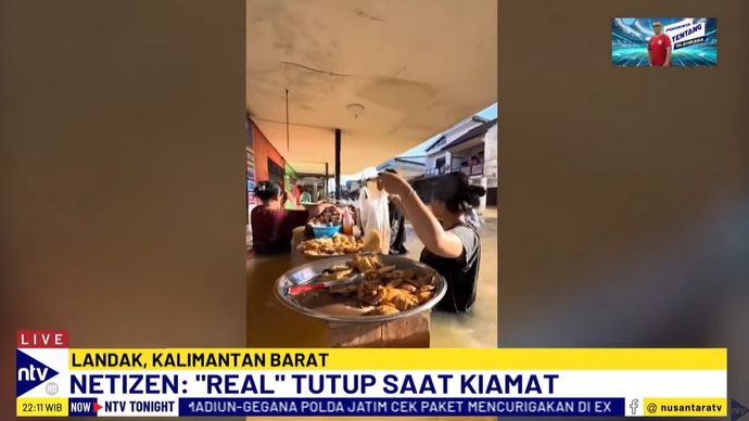 Seorang penjual gorengan yang tetap bertahan berjualan meskipun air banjir sudah mencapai setinggi dada orang dewasa.