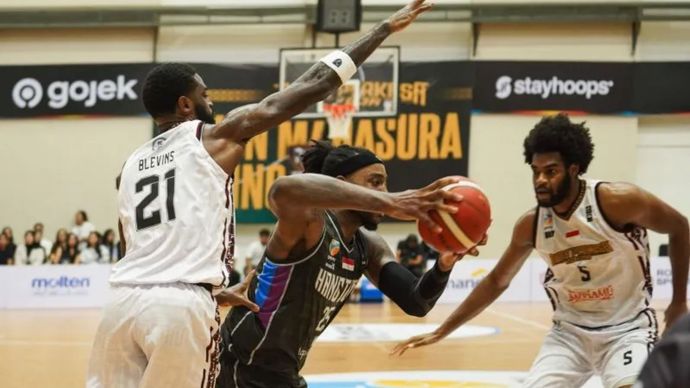 Pebasket Bima Perkasa Jogja Deshawn Blevins (kiri) mencoba menghadang pebasket Hangtuah Jakarta Rakeem Maleek Christmas (tengah) pada pertandingan IBL 2025 di GOR Pancasila, Sleman, DI Yogyakarta, Minggu