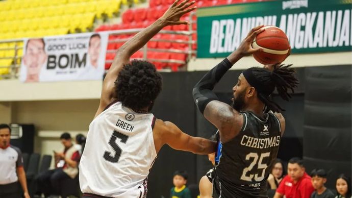 Pebasket Bima Perkasa Jogja Kierell Ardianus Green (kiri) mencoba menghadang pebasket Hangtuah Jakarta Rakeem Maleek Christmas (tengah) pada pertandingan IBL 2025 di GOR Pancasila, Sleman, DI Yogyakarta, Minggu