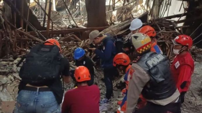 Petugas gabungan berjalan di halaman Gedung Glodok Plaza