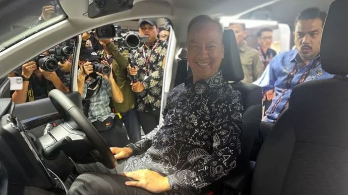 Menteri Perindustrian (Menperin) Agus Gumiwang Kartasasmita menjajal masuk ke dalam salah satu mobil yang dipamerkan di IIMS 2025, di JIExpo 