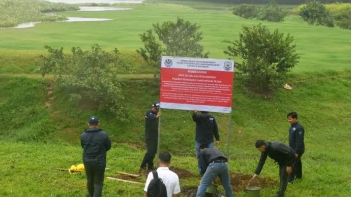  pengawas Penegakan Hukum (Gakkum) Kementerian Lingkungan Hidup memasang plang penyegelan di Kawasan Ekonomi