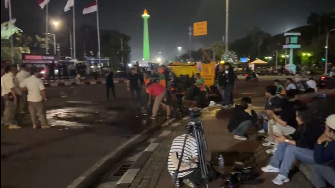 Petugas tengah membersihkan jalan dari material bekas aksi massa Indonesia Gelap. (NTVNews.id) 