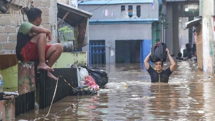 Warga berjalan melintasi banjir di kawasan Jalan Jembatan 1, Kramat Jati, Jakarta, Senin (3/3/2025). Kawasan di sepanjang aliran Kali Ciliwung tersebut terendem banjir setinggi 30 cm - 130 cm akibat luapan Bendungan Katulampa yang sudah mencapai siag