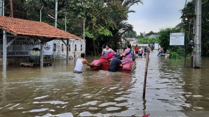 Ilustrasi - Sejumlah warga melintas genangan air menggunakan perahu karet saat hendak mengungsi ke tempat aman di Kabupaten Tangerang