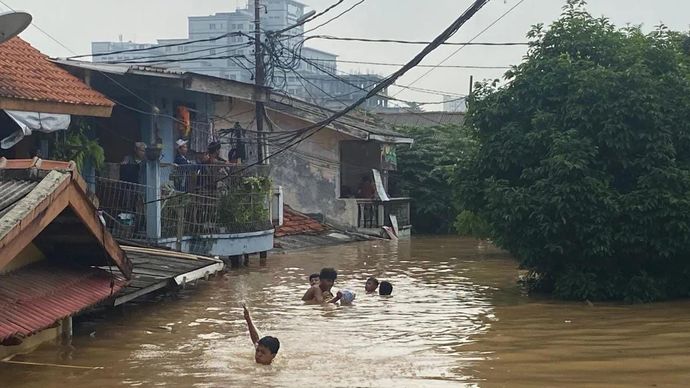 Anak-anak berenang di tengah banjir di kawasan Rawajati, Pancoran, Jakarta Selatan, Selasa (4/3/2025