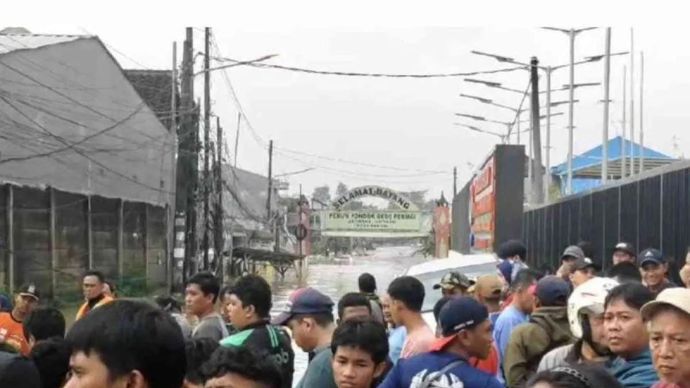 Sejumlah warga menyaksikan proses evakuasi korban banjir dari titik aman akses menuju Perumahan Pondok Gede Permai Kecamatan Jartiasih, Kota Bekasi, Jawa Barat, Selasa.