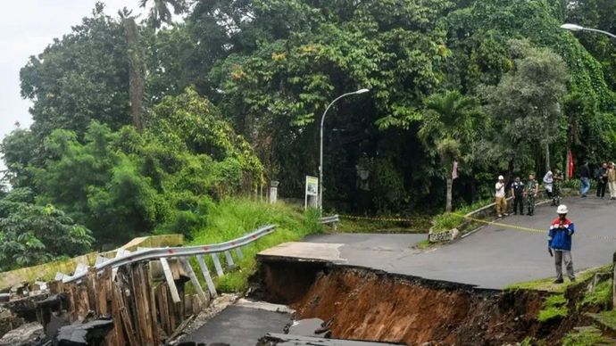 Petugas mengamati jalan yang amblas di jalan Saleh Danasasmita, Kota Bogor, yang diakibatkan Hujan deras dengan intensitas tinggi.