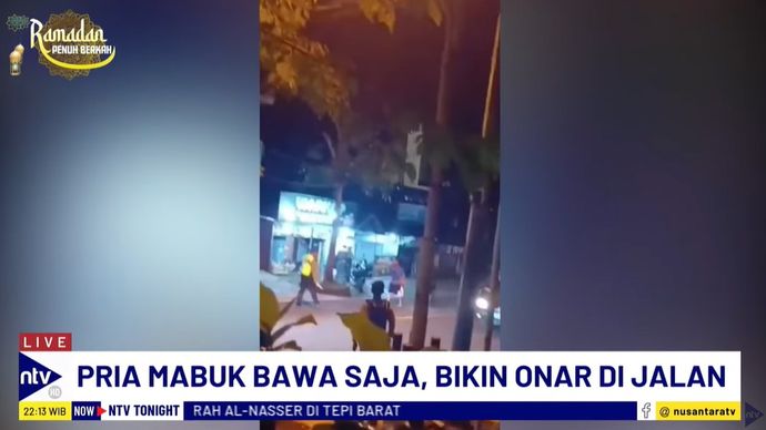 Pria mabuk tampak sedang mengamuk sambil membawa golok dan mengancungkan sajam ke arah polisi.