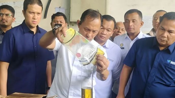 Brigjen Pol. Helfi Assegaf, Direktur Tindak Pidana Ekonomi Khusus (Dirtipideksus) sekaligus Kepala Satgas Pangan Polri, menuangkan MinyaKita produksi PT Binamas Karya Fausta ke dalam botol penakar saat inspeksi di Pergudangan Central Cakung.