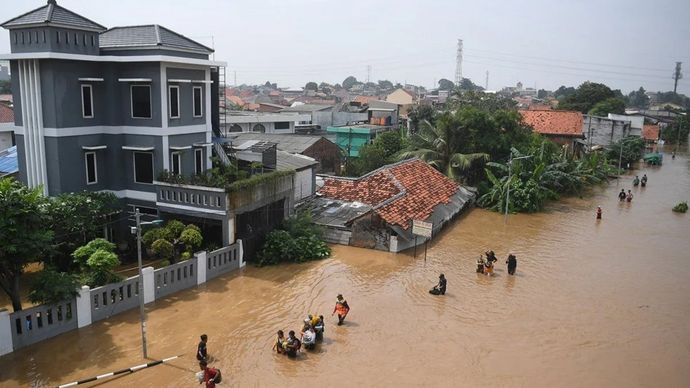 Warga melintasi banjir yang merendam kawasan Cililitan, Jakarta, Selasa (4/3/2025). Berdasarkan data BPBD DKI Jakarta, sebanyak 29 RT terdampak banjir dengan ketinggian 30-250 cm akibat luapan Sungai Ciliwung.