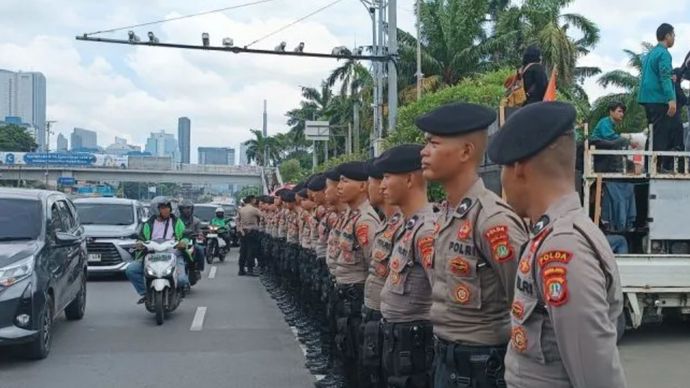 Petugas membuat pagar pembatas agar para pengunjuk rasa tidak masuk ke jalan raya di Jakarta.