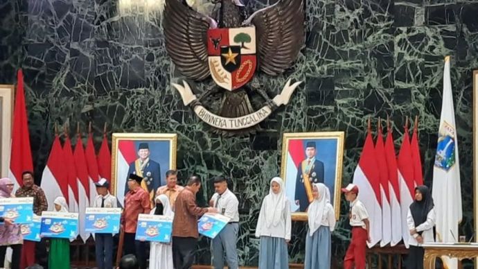 Gubernur Jakarta Pramono Anung saat memberikan dana bantuan sosial KJP Plus secara simbolis pada penerima, di Balai Kota, Jakarta, Kamis (20/3/2025)