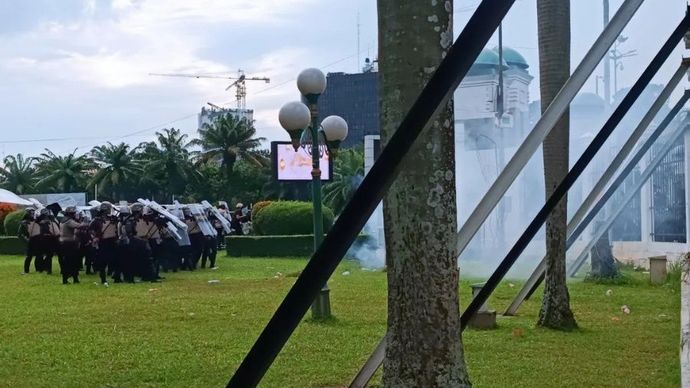 Petugas kepolisian saat menghalau massa yang sedang mencoba memanjat pagar di Jakarta, Kamis (20/3/2025).