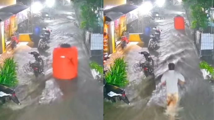 Seorang pria sedang berlari mengejar sebuah toren air yang terbawa arus banjir.