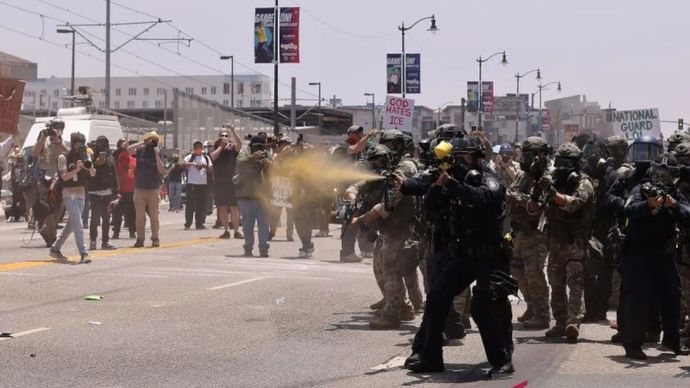 Di California, Los Angeles, Amerika Serikat, Minggu (8/6), polisi menyemprotkan gas air mata saat demonstrasi menentang kebijakan imigrasi berlangsung. Kebijakan Presiden Trump yang akan memindahkan imigran ilegal dan bermasalah itu ditentang dengan keras.