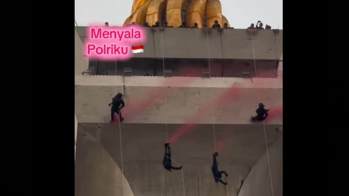 Brimob Polri terjun dari atas Monas menggunakan tali. 