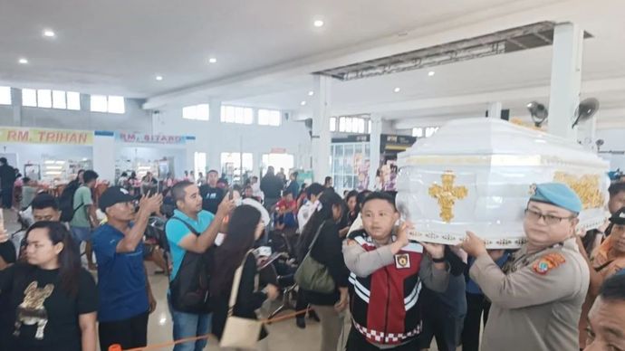 Petugas dibantu masyarakat mengangkat peti jenazah korban kecelakaan kebakaran KM Barcelona V di perairan Talise, Kabupaten Minahasa Utara. 