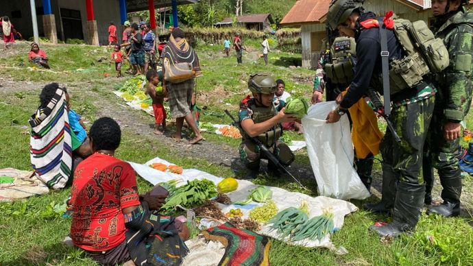 Prajurit TNI memborong hasil tani masyarakat Papua. 