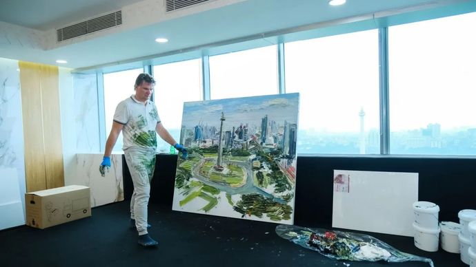 Pelukis asal Jerman, Christopher Lehmpfuhl melukis Monumen Nasional (Monas) dari lantai 23 gedung Balai Kota Jakarta, Rabu, 30 Juli 2025.