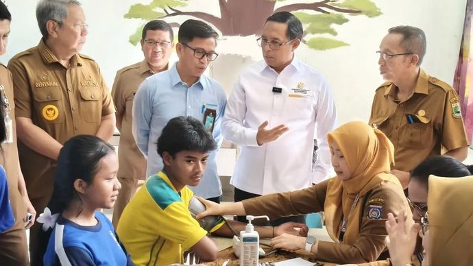Kepala Kantor Komunikasi Kepresidenan (PCO) Hasan Nasbi didampingi Kepala Badan Kebijakan Pembangunan Kesehatan Kemenkes RI, Asnawi Abdullah (kiri) memantau pelaksanaan Cek Kesehatan Gratis (CKG) di SMAN 6 Tangerang Selatan, Senin 4 Agustus 2025. (ANTARA/Andi Firdaus)