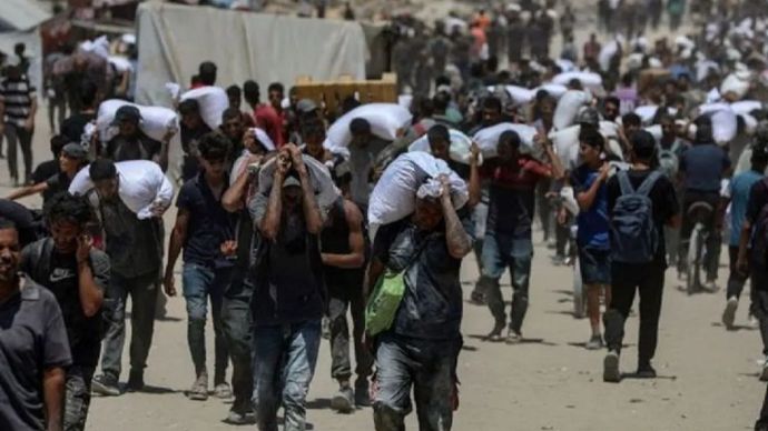 Warga membawa bantuan kemanusiaan di Beit Lahia, Jalur Gaza utara, Palestina (1/8/2025).