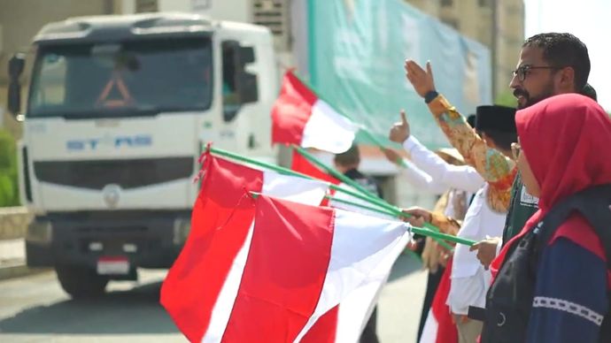 Relawan mengibarkan bendera Merah Putih saat melepas keberangkatan truk bantuan pangan BAZNAS untuk masyarakat Gaza.