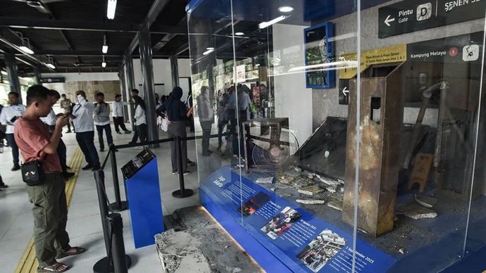 Calon penumpang mengamati instalasi puing-puing sisa kerusakan akibat kerusuhan di Halte Jaga Jakarta, Senen, Jakarta Pusat, Senin (8/9/2025). Pemprov DKI Jakarta mengubah nama Halte Transjakarta Senen Sentral menjadi Halte Jaga Jakarta pascarusak parah akibat unjuk rasa pada (29/8/2025). 