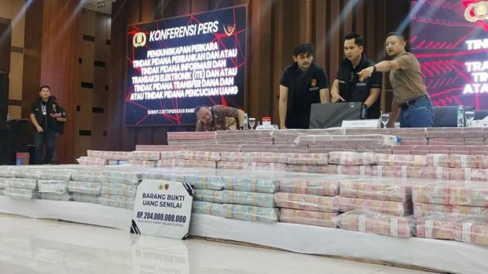 Penyidik pada Direktorat Tindak Pidana Ekonomi Khusus (Dittipideksus) Bareskrim Polri menyusun tumpukan uang senilai Rp204 miliar hasil sitaan dari kasus pembobolan rekening dormant dalam konferensi pers di Gedung Bareskrim Polri, Jakarta, Kamis (25/9/2025). 