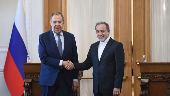 Menteri Luar Negeri (Menlu) Iran Seyed Abbas Araghchi (kanan) berjabat tangan dengan Menlu Rusia Sergei Lavrov dalam sebuah konferensi pers bersama di Teheran, Iran, pada 25 Februari 2025.