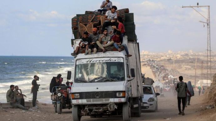 Warga Palestina yang mengungsi memindahkan barang-barang mereka di sepanjang pantai dekat wilayah al-Nuseirat di Jalur Gaza tengah, pada 25 September 2025.