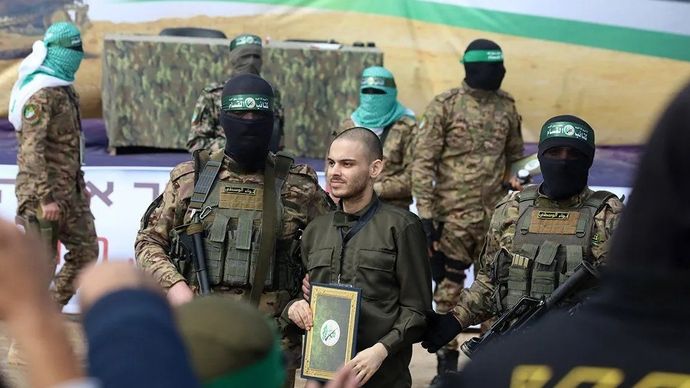 Arsip foto - Anggota Brigade Al-Qassam, sayap bersenjata Hamas, dan seorang sandera Israel terlihat selama penyerahan tiga sandera Israel kepada Komite Internasional Palang Merah, di kamp pengungsi al-Nuseirat, di Gaza, Palestina, 22 Februari 2025. ANTARA/Xinhua/Rizek Abdeljawad/aa.
