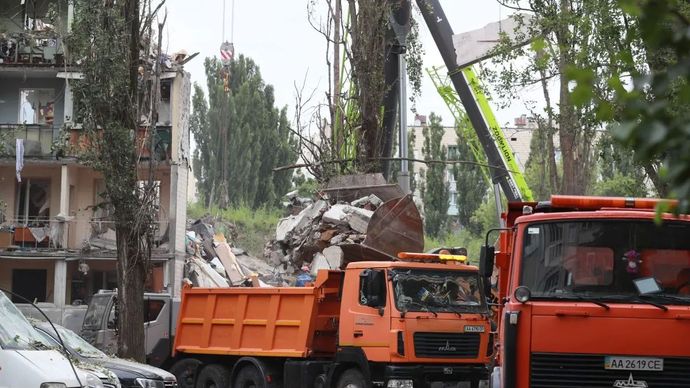 Warga membersihkan puing-puing setelah serangan Rusia di Distrik Sviatoshinskyi, Kiev, Ukraina pada 31 Juli 2025. 