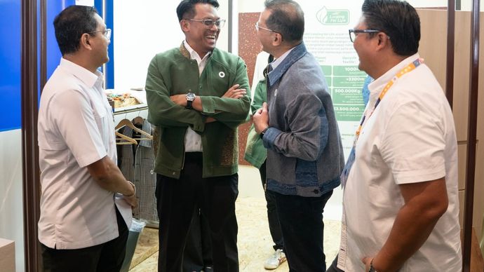 Corporate Secretary Bank Mandiri M. Ashidiq Iswara (kedua dari kiri) berbincang bersama pengunjung di booth Looping for Life pada ajang Livin’ Fest 2025 di Nusantara International Convention Exhibition (NICE), PIK 2, Tangerang. Melalui program ini, Bank Mandiri mengajak masyarakat berpartisipasi dalam aksi keberlanjutan dengan mengolah limbah tekstil menjadi produk fesyen bernilai ekonomi tinggi.