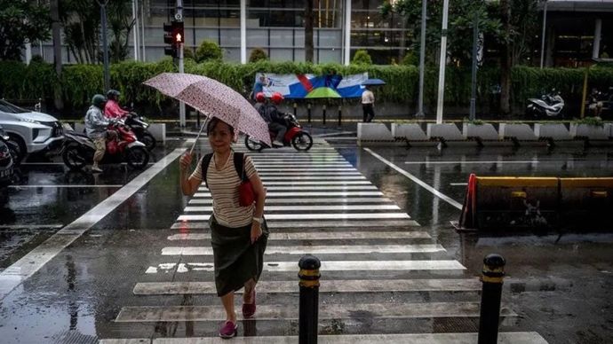 Arsip - Seorang warga menggunakan payung saat turun hujan di kawasan Bundaran HI, Jakarta. ANTARA FOTO/Erlangga Bregas Prakoso/Spt.