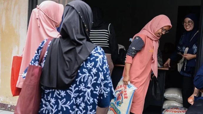 Warga membawa beras bantuan saat penyaluran bantuan sosial beras di Kecamatan Walantaka, Kota Serang, Banten, Kamis (18/9/2025). Kementerian Sosial (Kemensos) mencatat penyaluran bantuan sosial (bansos), salah satunya sembako atau Bantuan Pangan Non-Tunai (BPNT) pada triwulan ketiga tahun 2025 sudah menyasar 13,6 juta penerima manfaat. ANTARA FOTO/Muhammad Bagus Khoirunas/YU