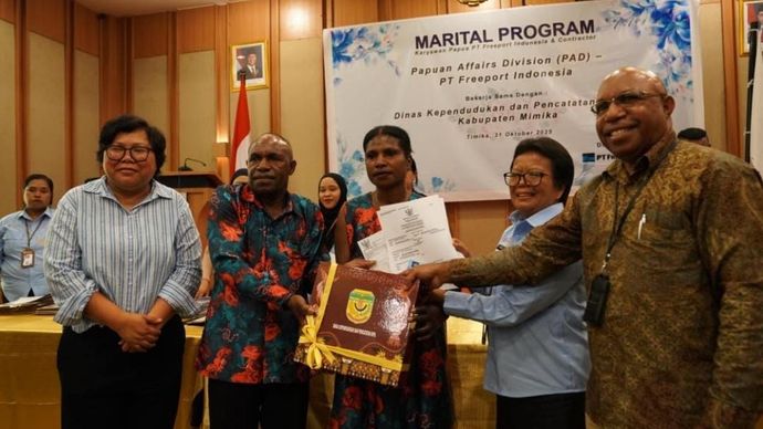 Vice President Government Relations PTFI  Lenny Josephina (paling kiri) dan VP  Papuan Affairs Division (PAD) Soleman  Faluk (paling kanan) bersama salah satu  pasangan Marital Program  usai menerima  dokumen Catatan Sipil.