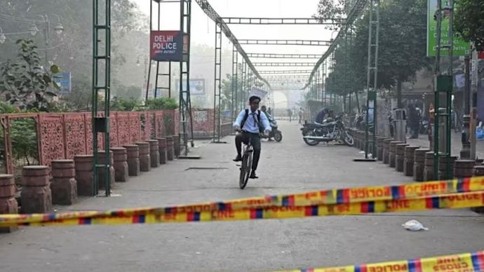 Seorang pria mengendarai sepedanya melewati lokasi ledakan, setelah ledakan di area Benteng Merah di kawasan tua Delhi, pada 12 November 2025. (Foto: AFP/Arun&nbsp;Sankar)