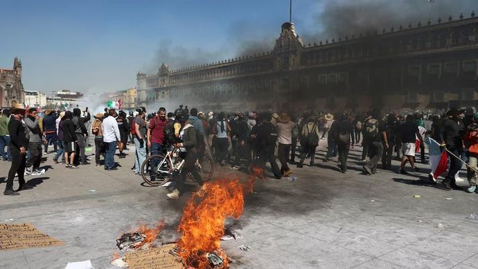 Api berkobar selama protes terhadap ketidakamanan dan korupsi di negara itu, di luar Istana Nasional, di Mexico City, Meksiko, 15 November 2025.