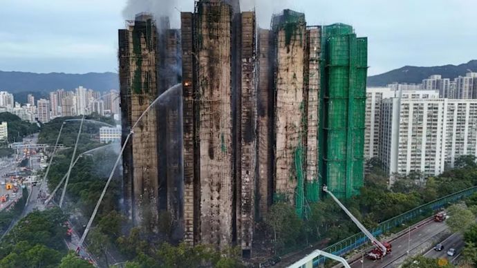 Sebuah tampilan drone menunjukkan kobaran api dan asap tebal yang mengepul dari perumahan Wang Fuk Court selama kebakaran besar, di Tai Po, Hong Kong, Cina, pada 27 November 2025. (Foto: Reuters/Tyrone&nbsp;Siu)