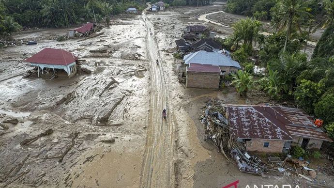 Foto udara warga melintas di permukiman Jorong Kayu Pasak yang rusak akibat banjir bandang di Nagari Salareh Aia, Palembayan, Agam, Sumatera Barat, Minggu (30/11/2025). ANTARA FOTO/Wahdi Septiawan/rwa/am.