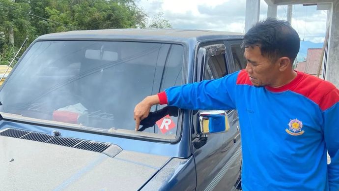 Warga di Kecamatan Canduang, Kabupaten Agam menunjuk tumpukan abu vulkanik yang jatuh ke kendaraannya setelah erupsi Gunung Marapi yang terjadi pada Selasa 2 desember 2025. ANTARA/AL Fatah.