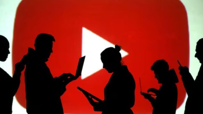 Siluet pengguna laptop dan perangkat seluler terlihat di samping proyeksi layar logo Youtube dalam ilustrasi gambar ini yang diambil pada 28 Maret 2018. (Foto: Dok/Dado Ruvic/Reuters) 