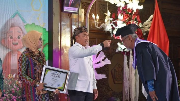 Mendukbangga/Kepala BKKBN Wihaji (berkemeja putih) bersama sang istri di sebelah kirinya saat mewisuda salah satu siswa Sekolah Lansia di Kabupaten Lamongan, Jawa Timur, pada Kamis, 4 Desember 2025. ANTARA/HO-Kemendukbangga/BKKBN.