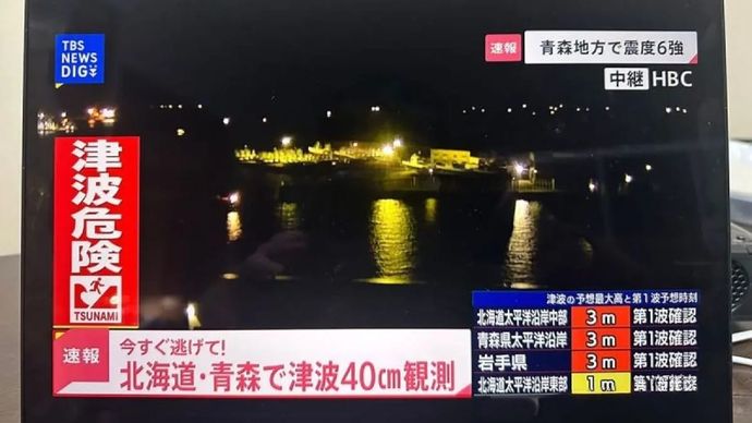 Foto ini yang diambil dengan ponsel menunjukkan informasi gempa bumi yang ditampilkan di layar di Tokyo, Jepang, Selasa (9/12/2025). Gempa dengan magnitudo awal 7,6 mengguncang Jepang timur laut pada Senin malam, dengan gelombang tsunami setinggi 40 