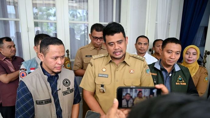 Gubernur Sumatera Utara Bobby Afif Nasution (tengah) didampingi Wali Kota Pekanbaru Agung Nugroho usai menyerahkan bantuan uang tunai Rp1 miliar di rumah dinas Gubernur Sumut, Jalan Jenderal Sudirman Medan, Selasa, 9 Desember 2025. ANTARA/HO-Diskomin
