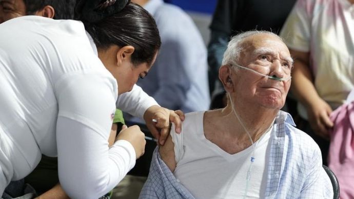 Seorang petugas kesehatan memberikan vaksin kepada seorang pria lanjut usia di pusat vaksinasi di Mexico City, ibu kota Meksiko, 12 November 2025. (ANTARA/Xinhua/Francisco Canedo)